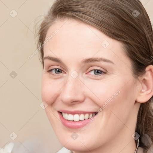 Joyful white young-adult female with long  brown hair and blue eyes