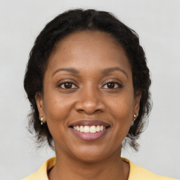 Joyful black adult female with medium  brown hair and brown eyes