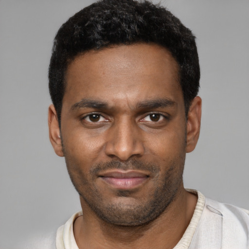 Joyful black young-adult male with short  black hair and brown eyes