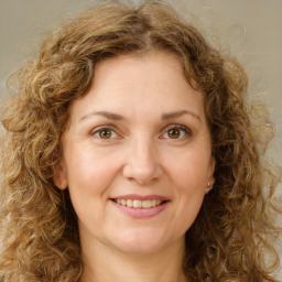 Joyful white young-adult female with medium  brown hair and green eyes