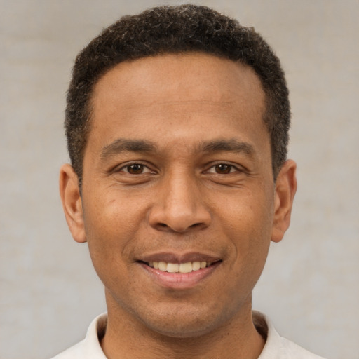 Joyful latino young-adult male with short  brown hair and brown eyes