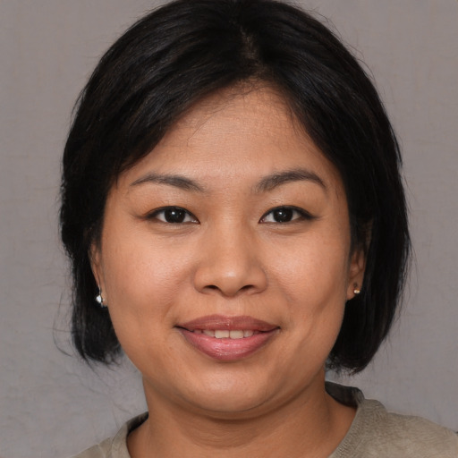 Joyful asian young-adult female with medium  black hair and brown eyes