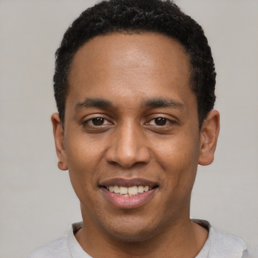 Joyful black young-adult male with short  black hair and brown eyes