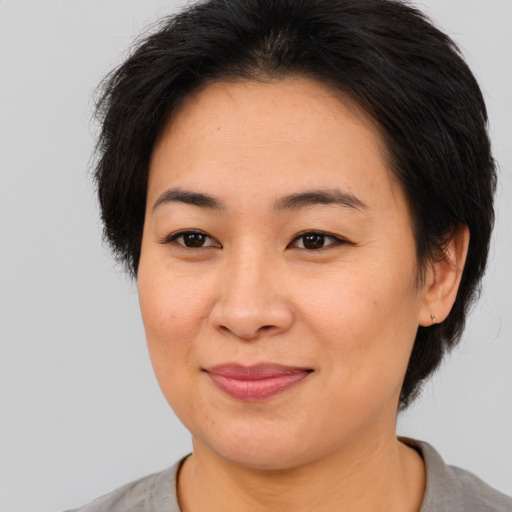 Joyful asian young-adult female with short  brown hair and brown eyes
