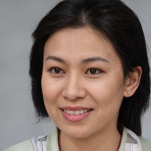 Joyful asian adult female with medium  brown hair and brown eyes