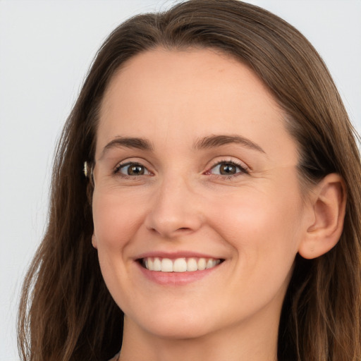 Joyful white young-adult female with long  brown hair and grey eyes