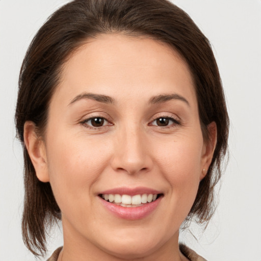 Joyful white young-adult female with medium  brown hair and brown eyes