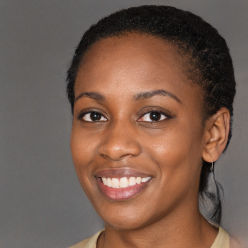 Joyful black young-adult female with long  black hair and brown eyes