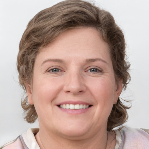 Joyful white young-adult female with medium  brown hair and blue eyes