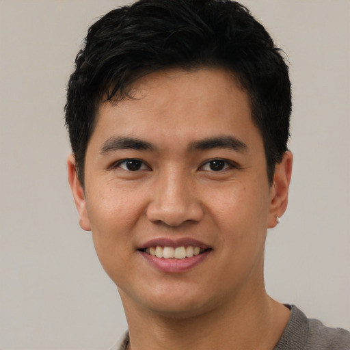 Joyful asian young-adult male with short  black hair and brown eyes