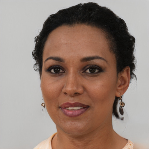 Joyful latino young-adult female with short  black hair and brown eyes