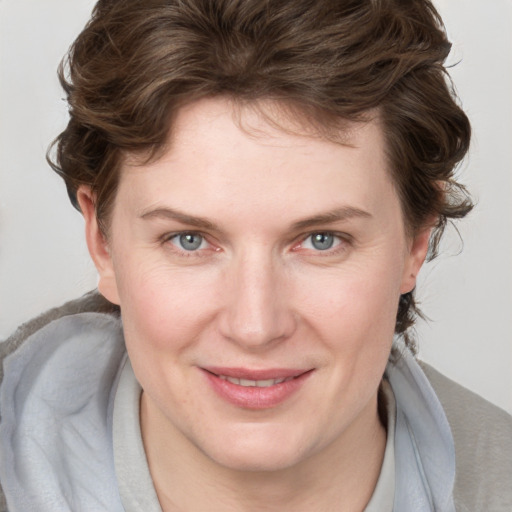 Joyful white young-adult female with medium  brown hair and blue eyes