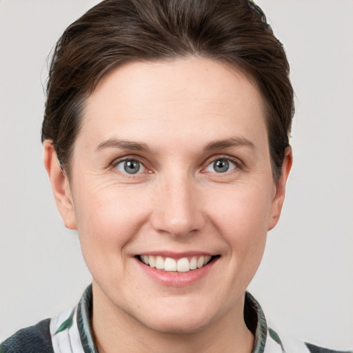 Joyful white young-adult female with short  brown hair and grey eyes