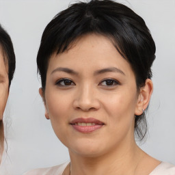 Joyful asian young-adult female with medium  brown hair and brown eyes