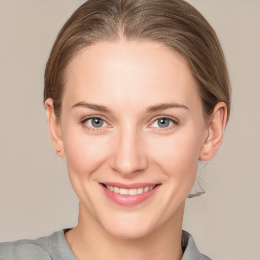 Joyful white young-adult female with medium  brown hair and grey eyes