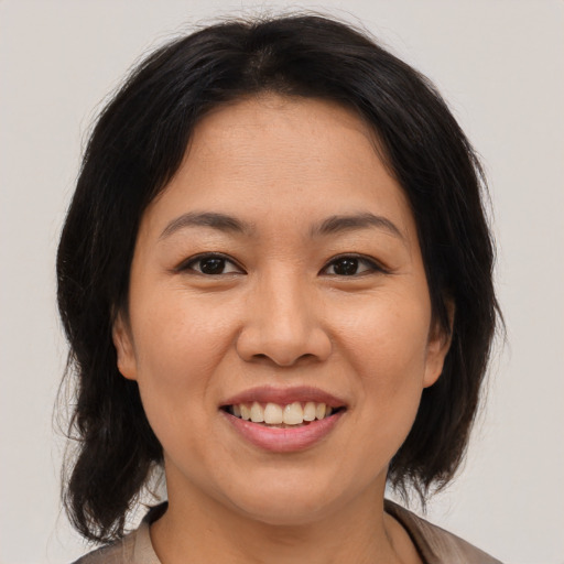 Joyful asian young-adult female with medium  brown hair and brown eyes