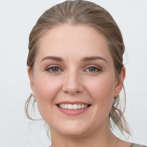 Joyful white young-adult female with medium  brown hair and grey eyes