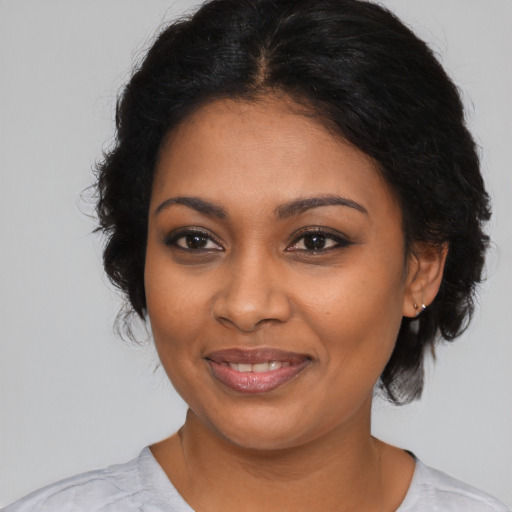 Joyful black young-adult female with medium  brown hair and brown eyes