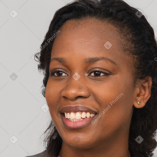 Joyful black young-adult female with long  black hair and brown eyes