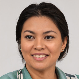 Joyful latino young-adult female with medium  brown hair and brown eyes