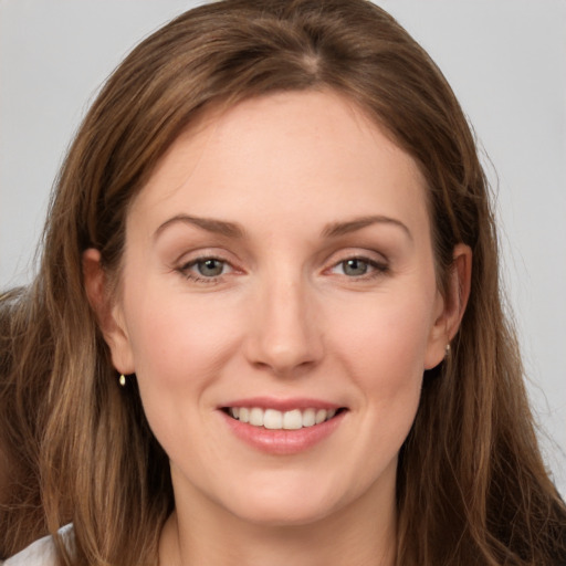 Joyful white young-adult female with long  brown hair and grey eyes