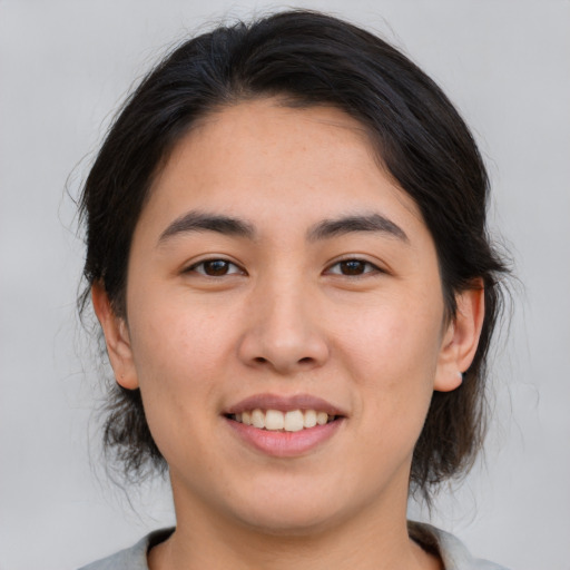 Joyful asian young-adult female with medium  brown hair and brown eyes