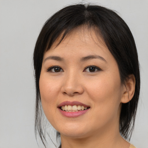 Joyful asian young-adult female with medium  brown hair and brown eyes