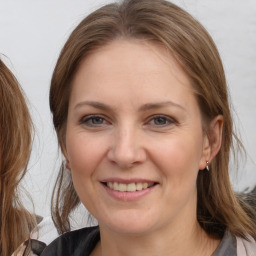 Joyful white adult female with medium  brown hair and grey eyes