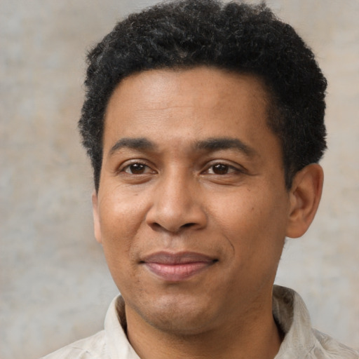 Joyful black adult male with short  black hair and brown eyes
