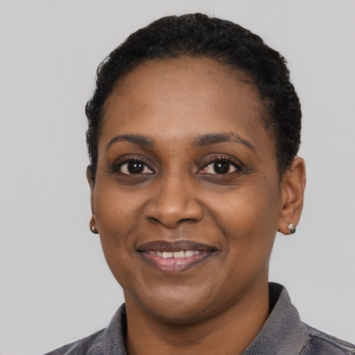 Joyful black adult female with short  black hair and brown eyes