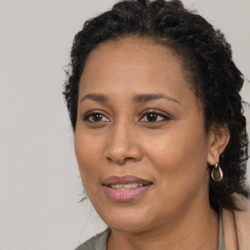 Joyful black young-adult female with long  black hair and brown eyes