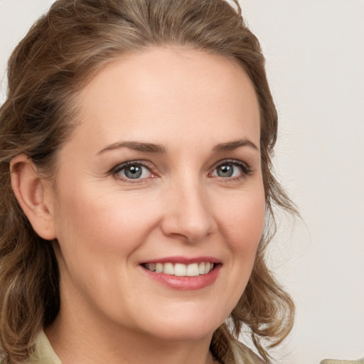 Joyful white young-adult female with medium  brown hair and green eyes