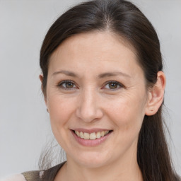 Joyful white adult female with long  brown hair and brown eyes