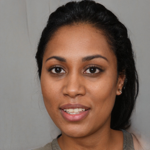Joyful black young-adult female with medium  black hair and brown eyes