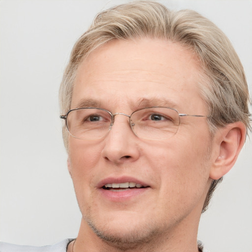 Joyful white middle-aged male with short  brown hair and blue eyes