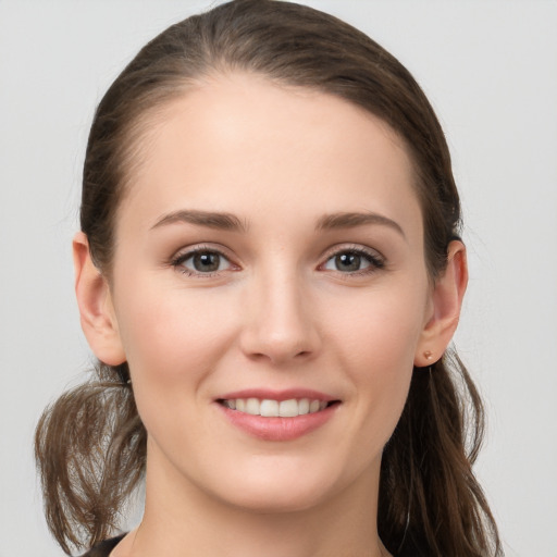 Joyful white young-adult female with long  brown hair and grey eyes