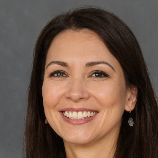 Joyful white adult female with long  brown hair and brown eyes