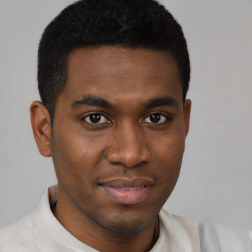 Joyful black young-adult male with short  brown hair and brown eyes