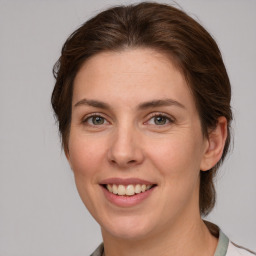 Joyful white young-adult female with medium  brown hair and grey eyes