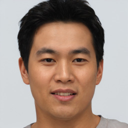 Joyful asian young-adult male with short  black hair and brown eyes