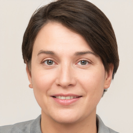 Joyful white young-adult female with short  brown hair and grey eyes