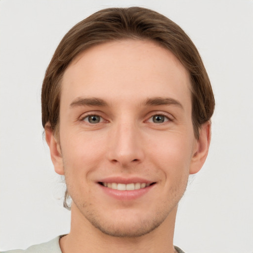 Joyful white young-adult male with short  brown hair and grey eyes