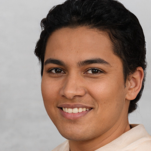 Joyful latino young-adult male with short  brown hair and brown eyes
