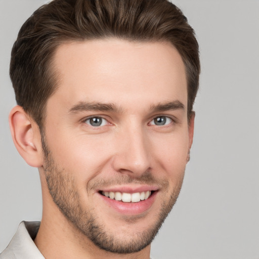 Joyful white young-adult male with short  brown hair and grey eyes