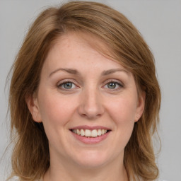 Joyful white young-adult female with medium  brown hair and grey eyes