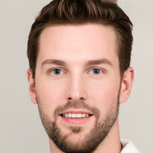 Joyful white young-adult male with short  brown hair and grey eyes