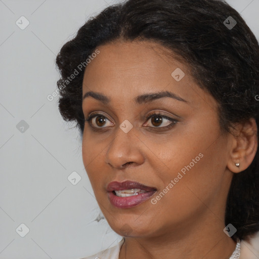 Joyful black young-adult female with long  black hair and brown eyes
