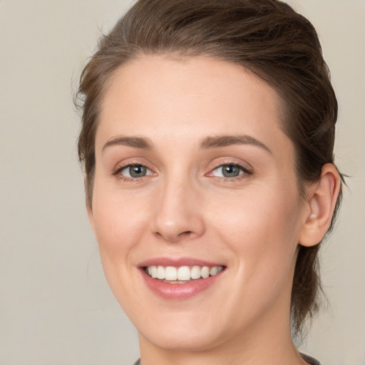 Joyful white young-adult female with medium  brown hair and green eyes