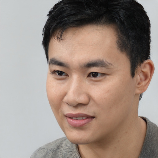 Joyful asian young-adult male with short  black hair and brown eyes