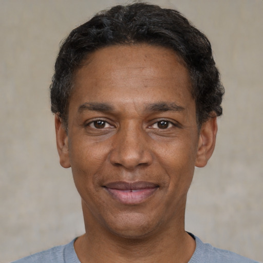 Joyful black adult male with short  black hair and brown eyes
